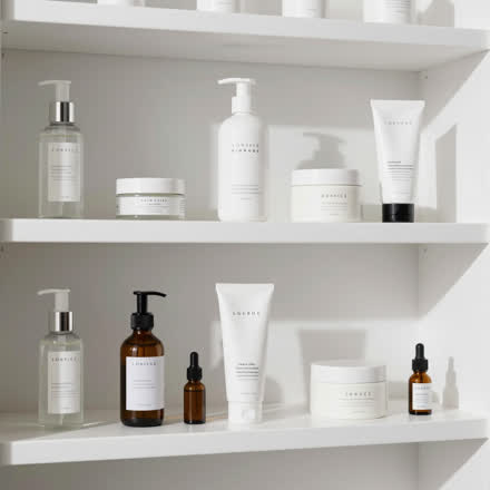 Produtos de skincare numa prateleira branca.