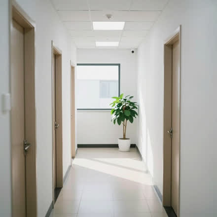 Corredor claro de uma clínica pequena, com planta.